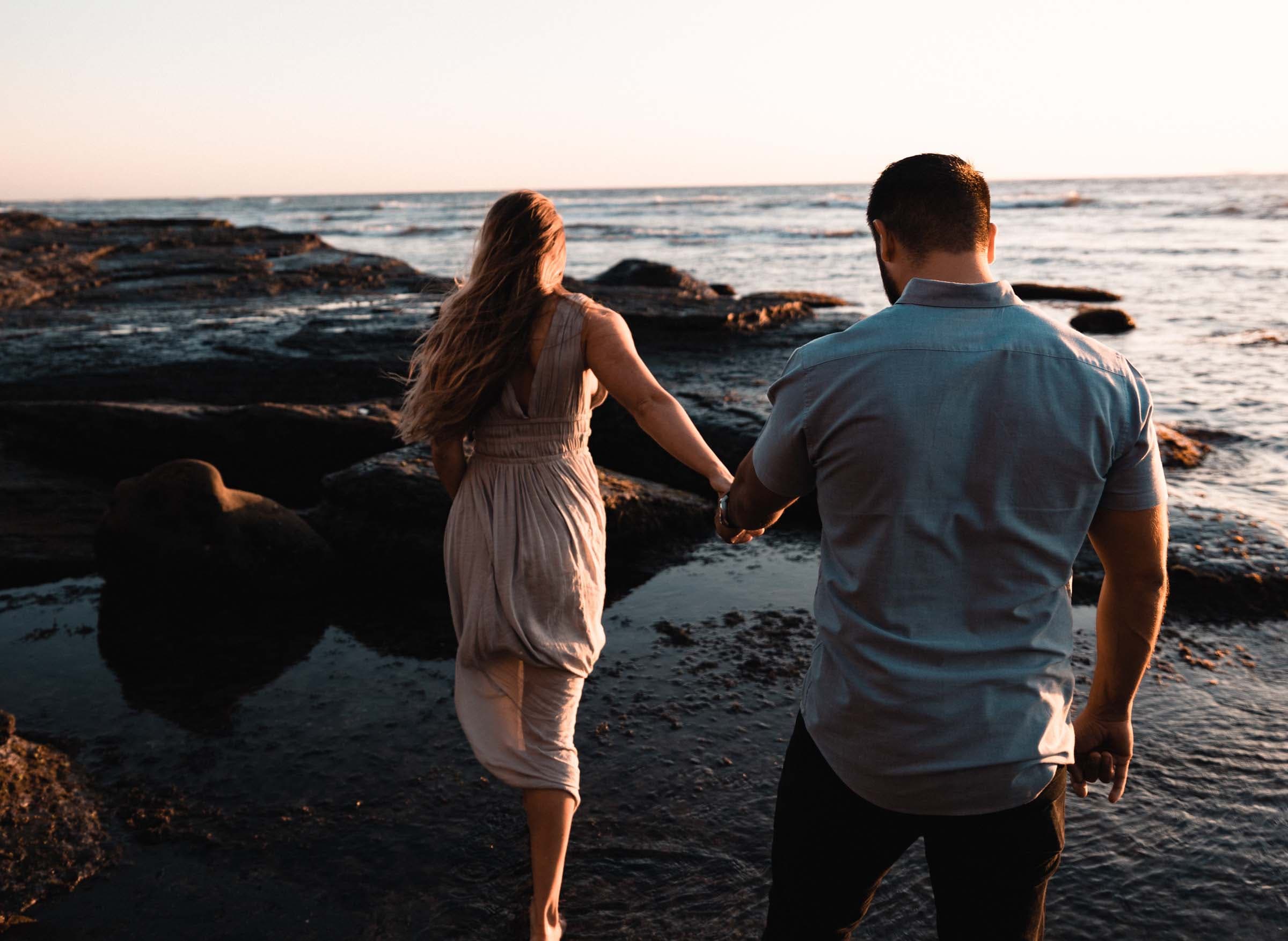 pareja-de-enamorados-caminando-tomados-de-la-mano-bajo-el-atardecer-frente-al-mar