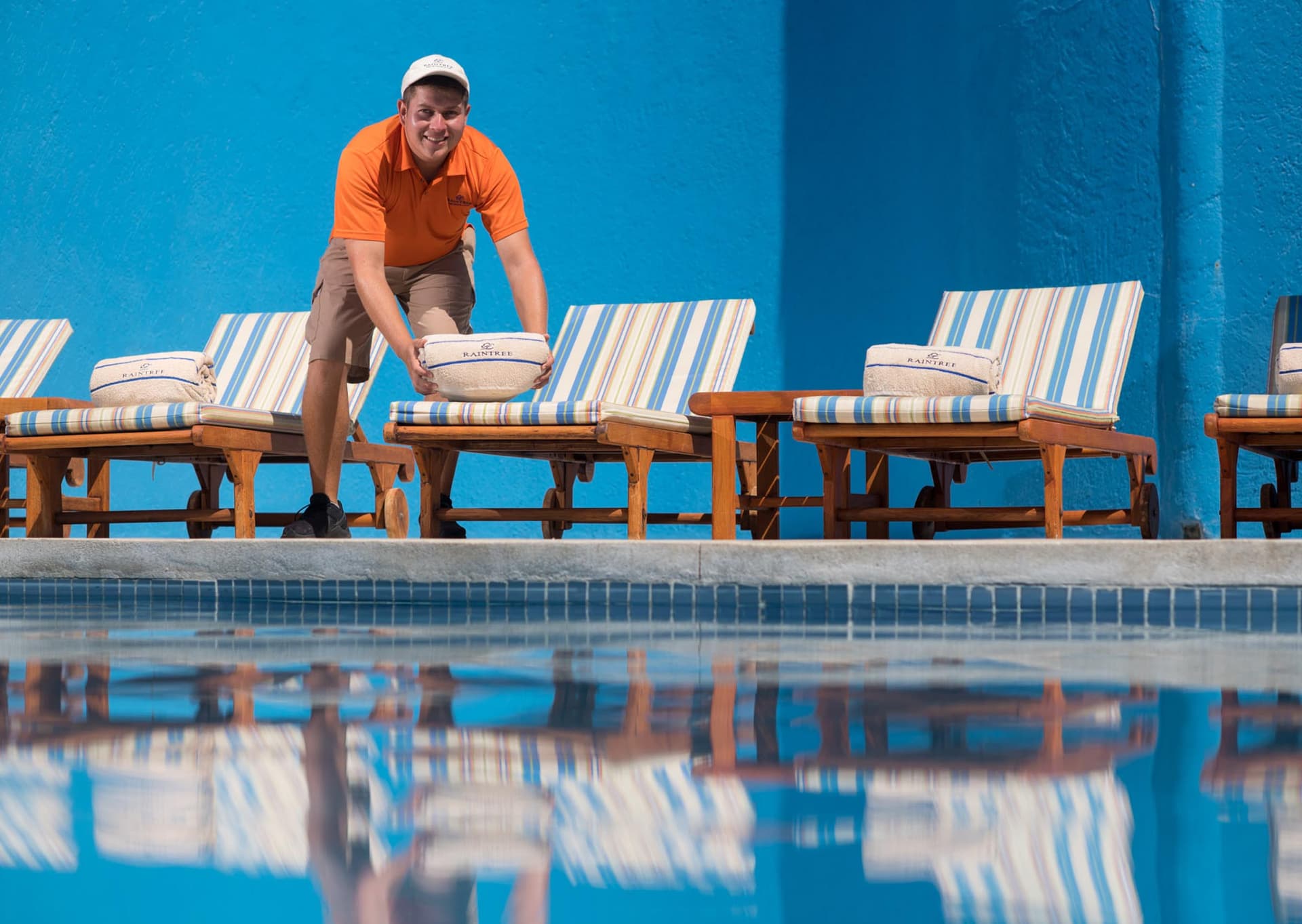 person-accommodating-couch-cushion-in-front-of-the-pool